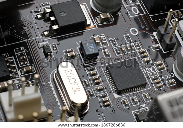 Smd chip ethernet\
microcontroller on brown motherboard with a lot of surface mount\
components resistors, capasitors, transistors, crystal oscilator,\
inductor and plugs.