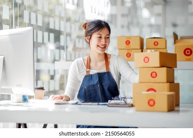 SME entrepreneur Small business entrepreneurs Online selling ideas,Happy Young Asian business owner work on computer and a boxs at home,delivery SME procurement package box deliver to customers,  - Shutterstock ID 2150564055