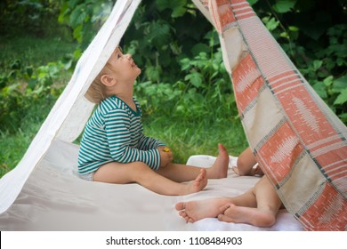 Smeared children play in nature in an improvised house. Homemade tent, hut, for fun girls and boys. Camping - Powered by Shutterstock