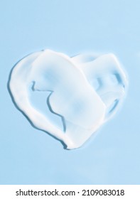 Smears of cream on a blue background in the shape of a heart. White cosmetic texture for skin care, top view. Health care, beauty concept. - Shutterstock ID 2109083018