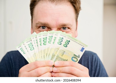 The Smell of Euro. Scent of a money. Man covering face with hundreds of Euro banknotes. Gamblers look. Financial machinations, fraud, swindle, tax evasion. - Shutterstock ID 2026408394