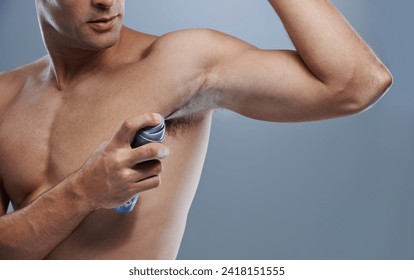 Smell, wellness and man spray deodorant for hygiene, fragrance or fresh scent after shower on studio background. Perfume, product or model spraying armpit to prevent odor and mockup space with person - Powered by Shutterstock