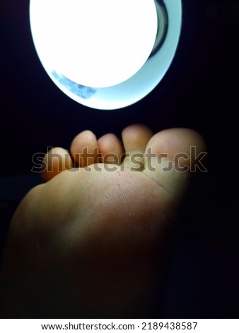 smelly male foot under light