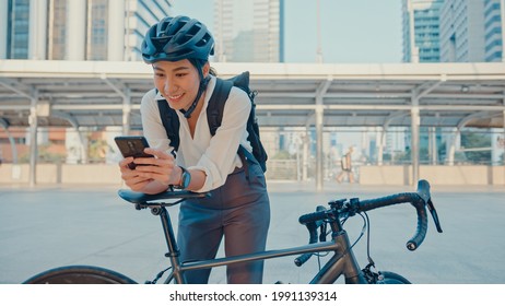 Smile Asian Businesswoman With Backpack Use Smart Phone Look Camera In City Stand At Street With Bike Go To Work At Office. Sport Girl Use Phone For Work. Commute To Work, Business Commuter In City.