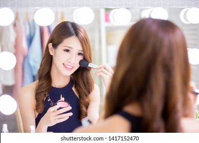 Smile Asian Woman With Makeup Brushes Near Face And Look Mirror At Home