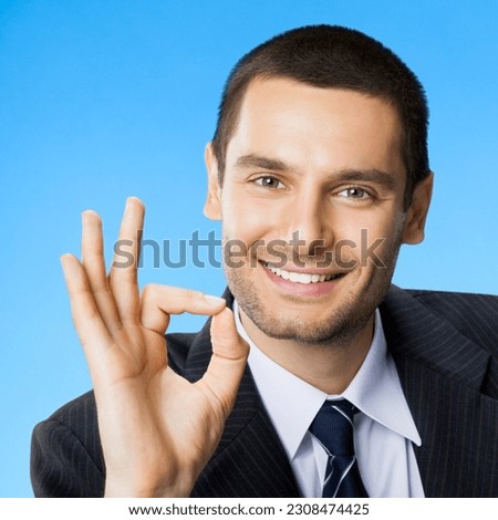 Smile businessman wear confident suit show make ok okay hand sign, isolated office caller worker,  sky blue background. Happy gesturing man. Business success concept. Square photo