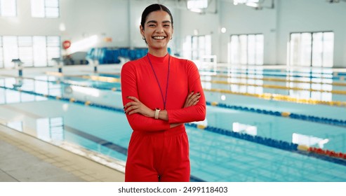 Smile, crossed arms and portrait of swimming instructor at indoor pool for lesson, workout or training. Happy, confident and woman coach with pride for competition practice at aquatic center. - Powered by Shutterstock