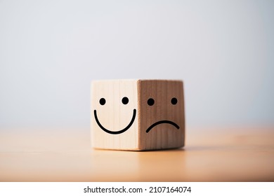 Smile face in bright side and sad face in dark side on wooden block cube for positive mindset selection concept. - Shutterstock ID 2107164074
