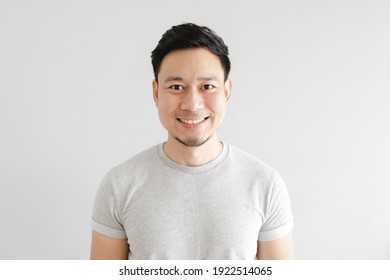 Smile Face Of Happy Asian Man Wear Grey T-shirt And On Grey Background.