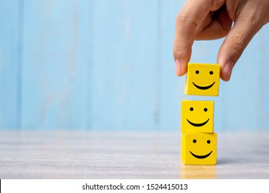 smile face on yellow wood cube. Service rating, ranking, customer review, satisfaction and emotion concept. - Shutterstock ID 1524415013