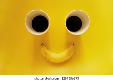 Smile face two paper cups of coffee with banana on yellow background - Shutterstock ID 1287356293