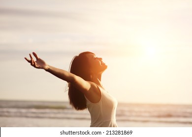 Smile Freedom and happiness woman on beach. She is enjoying serene ocean nature during travel holidays vacation outdoors. asian beauty