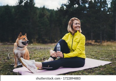 Smile Girl  With Pet Together Relax After Exercising Outdoors On Yoga Mat, Shiba Inu Dog On Nature, Fitness Woman Drink Water From Thirst Isolation Training Outside