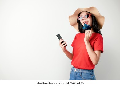 Smile Happily Asian Woman Red T-shirt Holding Smartphone And Credit Card Shopping Online On White Background.