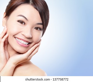 Smile happy Face of beautiful woman with health teeth and skin isolated on blue background. Beautiful young asian woman model
