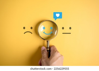 Smile happy face inside of magnifier glass with love icon massge between sad and normal emotion, Positive emotion, Mental health care concept. - Shutterstock ID 2256229555