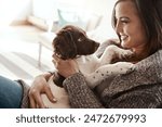 Smile, happy and woman with dog on sofa bonding with pet in living room at apartment. Relaxing, animal and female person cuddle, hug and embrace puppy with love and care on couch in lounge at home.