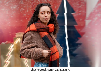 Smile happy   woman in a jacket and orange scarf walking outdoors in a celebration city before Christmas,  meeting with friends and looking for presents - Shutterstock ID 2236133577
