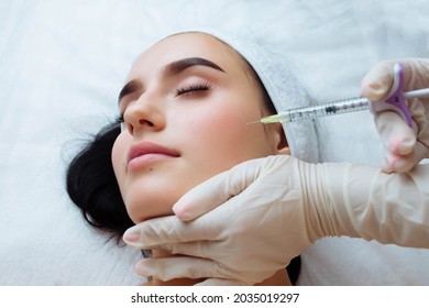 Smile Lifting And Lip Augmentation. Beautician Doctor Hands Doing Beauty Procedure To Female Face With Syringe. Young Woman's Mouth Contouring With Filler Injection. Marionette Lines Treatment