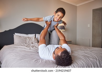 Smile, Love And Happy Father And Son Family Time Playing In Bedroom Bed Lifting Him Like Airplane Or Superhero. Loving Dad, Man Or Single Parent Bonding With Cheerful Kid In The Morning At Home.