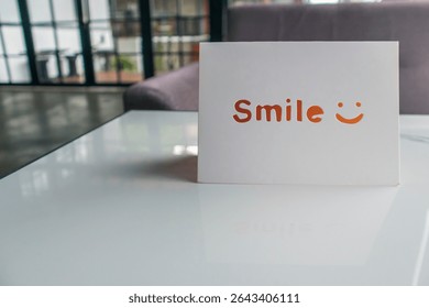 a smile note put on a table. card with a smile writing and emoticon