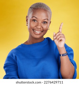 Smile, portrait and black woman in studio pointing up at product placement, mockup or information. Deal, promotion or announcement, happy model showing info space or notification on yellow background - Shutterstock ID 2276429711