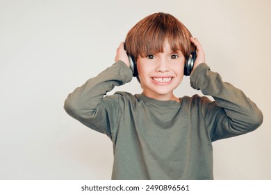 Smile, portrait and child in studio with headphones for sensory regulation with autism spectrum. Happy, mockup and boy kid with noise cancelling technology for stimulation control by white background - Powered by Shutterstock