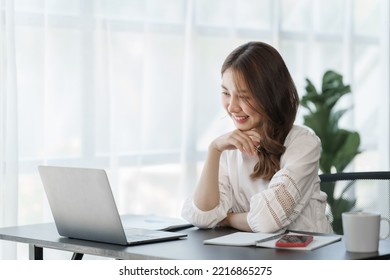 Smile Pretty business Asian woman freelancer is working her job on a laptop computer in a modern office. Doing accounting analysis report real estate investment data, Financial and tax systems concept - Shutterstock ID 2216865275