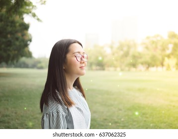 smile relaxing in the park by asian women, enjoying sunrise in the morning