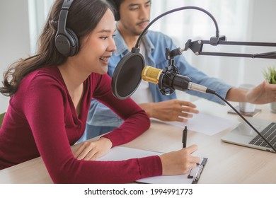 Smile two asian young woman, man radio hosts in headphones, microphone while talk, conversation, recording podcast in broadcasting at studio together. Technology of making record audio concept. - Powered by Shutterstock