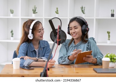 Smile two asian young woman, man radio hosts in headphones, microphone while talk, conversation, recording podcast in broadcasting at studio together. Technology of making record audio concept.
 - Powered by Shutterstock