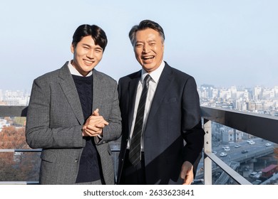 Smiles shared between two men on a sunny balcony in an urban setting with a cityscape view