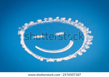 A smiley face drawn in the sky using clouds against a clear blue backdrop.