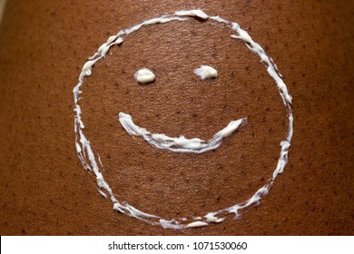 Smiley Face Drawn With Sun Cream Or Sunscreen Lotion On Dark Brown African American Skin Texture For Summer Skin Care And Health Concept.