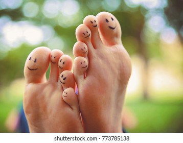 Smiley Faces On A Pair Of Feet On All Ten Toes In A Park On A Hot Summer Day Toned With A Vintage Retro Instagram Filter 