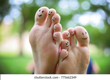 Smiley Faces On A Pair Of Feet On All Ten Toes In A Park On A Hot Summer Day 