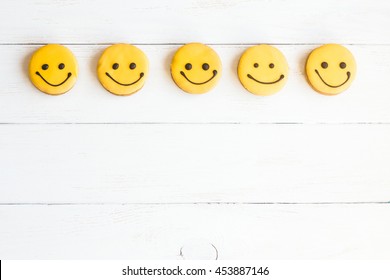 Smiley faces on wooden white background. Top view, flat lay 