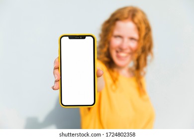 Smiley girl holding smartphone wearing yellow dress
 - Shutterstock ID 1724802358