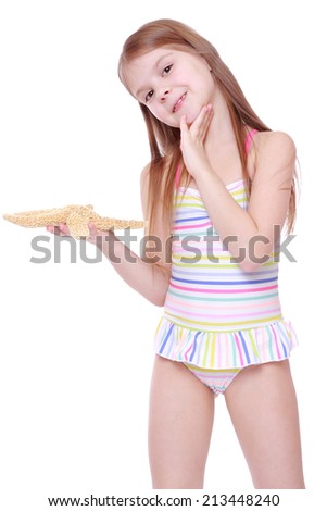 smiley kid wearing pink swimsuit holding big sea star isolated