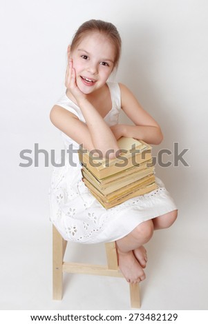 Smiley little girl holding vintage books