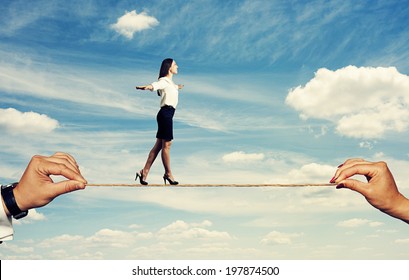 smiley woman walking on the rope over blue sky