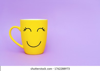 Smiley yellow coffee cup on purple background. Happy friday word concept. - Powered by Shutterstock