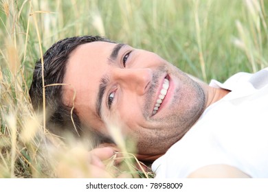 Smiling 40 Years Old Man Lying Down In A Field