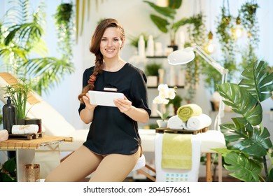 Smiling 40 Years Old Woman Worker In Modern Beauty Salon Using Tablet PC.