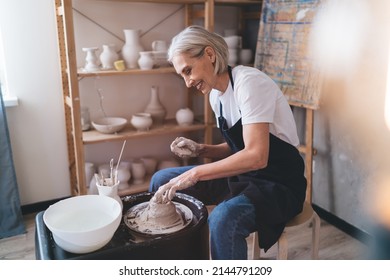 Smiling 50 Years Old Female Sculptor Making Clay Pot On Pottery Wheel. Concept Of Small Business And Entrepreneurship. Idea Of Home Hobby, Entertainment And Leisure. Woman Working At Art Studio