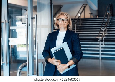Smiling 50's stylish, confident mature businesswoman, middle aged company ceo director, experienced senior female professional, business coach team leader on office background. Female leader.
