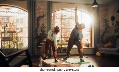 Smiling Active Senior Couple Doing Gymnastics and Yoga Stretching Exercises Together at Home on Sunny Morning. Concept of Healthy Lifestyle, Fitness, Recreation, Couple Goals, Wellbeing and Retirement - Powered by Shutterstock