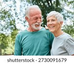 Smiling active senior couple jogging exercising and having fun and laughing together taking a break in the park