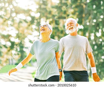 Smiling Active Senior Couple Jogging Together In The Park