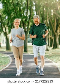 Smiling active senior couple jogging together in the park - Shutterstock ID 2179229213